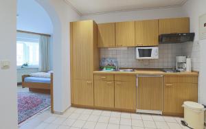 a kitchen with wooden cabinets and a microwave at Düne, App 12 in Duhnen