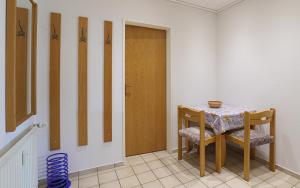 a room with a table and chairs and a door at Düne, App 12 in Duhnen