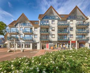 an apartment building with balconies and flowers at Düne, App 12 in Duhnen +7 photos