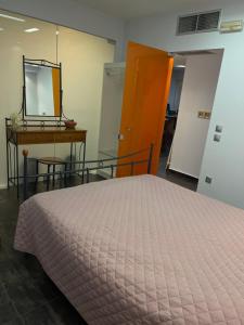 a bedroom with a bed and a mirror and a table at Cozy beach apartment in Saronida in Saronida