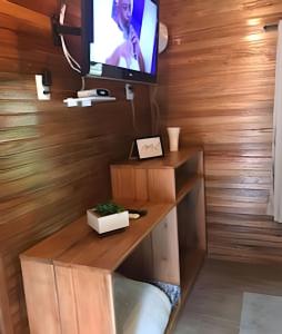 a living room with a tv and a wooden wall at Cabana surucuã in Três Coroas +32 photos
