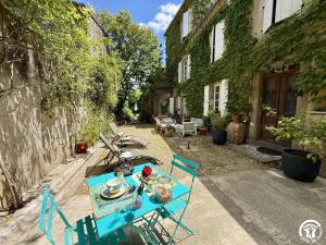 a blue table and chairs in front of a house at La calade in Douzens