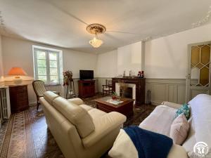 a living room with white furniture and a fireplace at La calade in Douzens