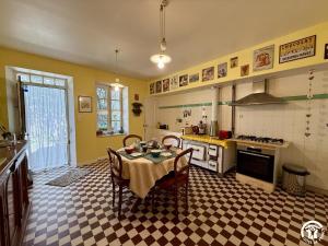 a kitchen with a table and chairs in a room at La calade in Douzens