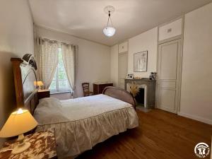 a bedroom with a bed and a table with a lamp at La calade in Douzens