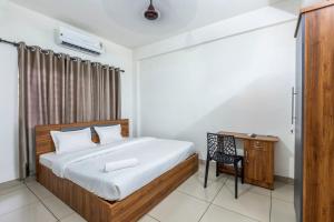 a bedroom with a bed and a desk at Oreo rooms in Kozhikode