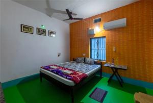 a bedroom with a bed and a table in it at Mangrove Pitta - Bhitarkanika in Kendrāparha