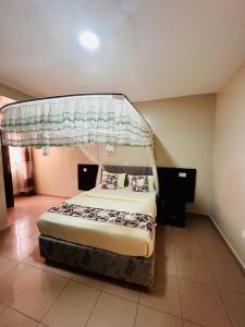 a bedroom with a bed with a canopy at Ebenezer resort hotel in Mbale