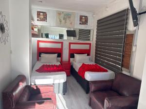 a small room with two beds and a couch at Aiden guest house in Gqeberha