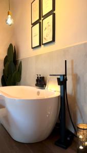 a bath tub in a bathroom with a plant at Falco Deluxe Home - Naples Airport & Town in Naples