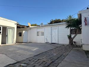 a white garage with a tree in front of it at Aiden guest house in Gqeberha