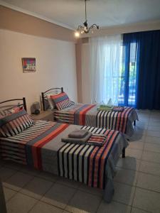 a bedroom with two beds and a window at Kalyves Beach in Kalives Poligirou +18 photos