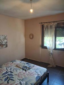a bedroom with a bed and a window at Kalyves Beach in Kalives Poligirou