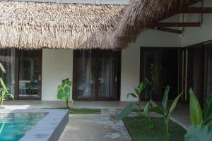 a resort with a pool and a thatch roof at Azarria Siargao Villas in General Luna