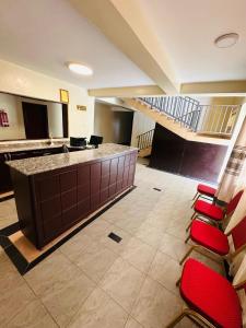 a lobby with a staircase and red chairs at Ebenezer resort hotel in Mbale