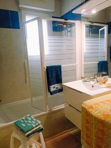 a bathroom with a tub and a sink and a shower at Mauguio-Carnon Apt T2 Tout Confort, Spacieux, Lumineux, Clim, Wifi, Balcon, parking privé, 15 mn des plages, de Montpellier in Mauguio