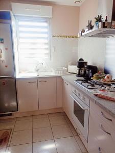 a kitchen with a sink and a stove top oven at Mauguio-Carnon Apt T2 Tout Confort, Spacieux, Lumineux, Clim, Wifi, Balcon, parking privé, 15 mn des plages, de Montpellier in Mauguio