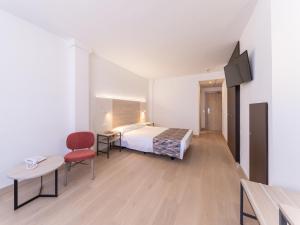 a hotel room with a bed and a tv at Hotel La Rápita in Sant Carles de la Ràpita