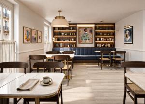 a restaurant with tables and chairs and a bench at Hôtel Beauvoisin in Paris