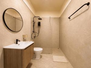 a bathroom with a toilet and a sink and a mirror at Beyond Stay Thong Lor 11 in Bangkok