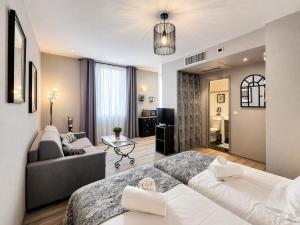 a living room with a bed and a couch at Suite Notre Dame - Appartements in Cannes