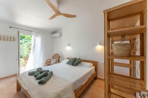 a bedroom with a large bed with a ceiling fan at Villas 19 Estrellas in Cala en Bosc +23 photos