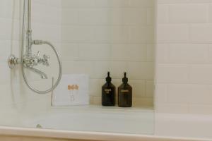 two bottles of wine sitting on a shelf in a shower at Hotel Bremon by Grup Duquessa in Cardona +30 photos