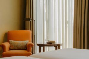 a room with a chair and a table and a window at Hotel Bremon by Grup Duquessa in Cardona