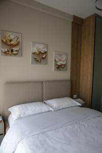 a bedroom with a bed with three paintings on the wall at Boulevard View in Tirana