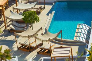 an overhead view of a swimming pool with chairs and umbrellas at Safrani Suites in Fira