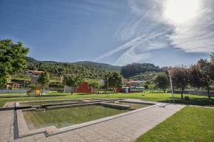 Ein Brunnen in einem Park mit einem Berg im Hintergrund in der Unterkunft Hotel De Cerva in Cerva