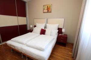 a bedroom with a large bed with white sheets and red pillows at Elegant Villa Hariz near Poreč - Fully AC & Large Pool in Gedići
