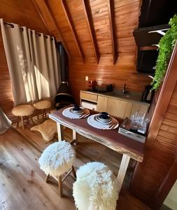 a living room with a table and a kitchen at Cabana Andorinha in Três Coroas