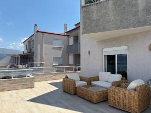 a patio with two wicker chairs on a balcony at Pogradec Lakeview Apartament in Pogradec