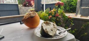 ein Teller mit einem Stück Essen auf einem Tisch mit einer Papaya in der Unterkunft My circle in Marigot + 12 Fotos