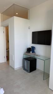a room with a desk and a television on a wall at Sunset Bay in Torre Suda