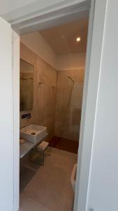 a bathroom with a tub and a sink and a shower at Sunset Bay in Torre Suda