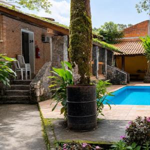 a house with a tree next to a swimming pool at Pousada Rancho Texas Ubatuba in Ubatuba +40 photos
