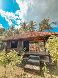 a house with a wooden porch with a table and chairs at The SUN House in Balian