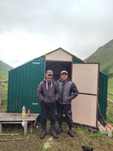 two men standing in front of a green tent at House Ali in Klyuchi