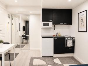 a kitchen with black and white appliances and a table at City Center Studio Pori in Pori
