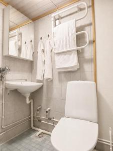a bathroom with a toilet and a sink and towels at City Center Studio Pori in Pori