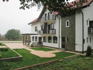 a large white building with a large yard at ,, La Moara '' in Peştişani