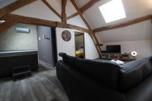 a living room with a couch and a television at Mise au Verre in Prémeaux