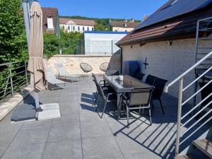 a patio with a table and chairs and an umbrella at Mise au Verre in Prémeaux