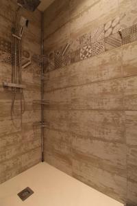 a shower in a bathroom with a wooden wall at Mise au Verre in Prémeaux +14 photos