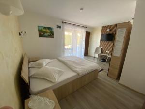 a bedroom with a large bed with white sheets at Casa Maruska in Murighiol