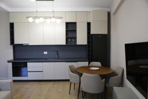 a kitchen with white cabinets and a table and chairs at Boulevard View in Tirana +10 photos