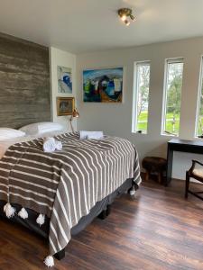a bedroom with a black and white bed and a piano at City Hall Apartments in Borgarnes