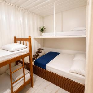 a small bedroom with two bunk beds and a staircase at Pousada Rancho Texas Ubatuba in Ubatuba